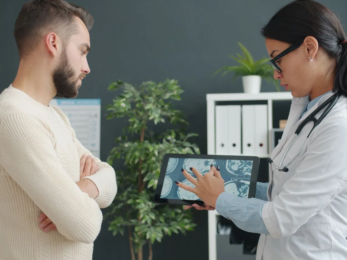 A doctor reviews results on a tablet with a patient